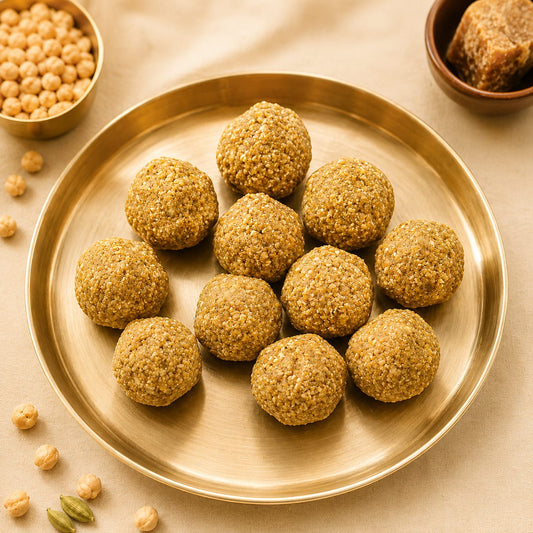 Healthy energy laddu balls served on a golden brass plate with chickpeas and jaggery.